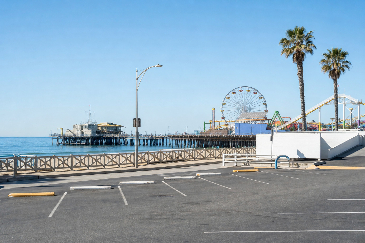 Santa Monica Pier and empty striped parking lot with palm trees